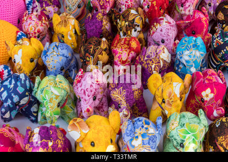 Bunte Spielzeug-Elefanten in gemusterten Fabic, die auf einem Marktplatz in thailand für Touristen Geschenke verkauft werden. Stockfoto