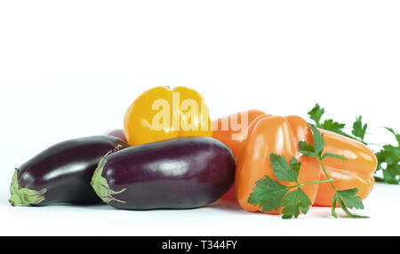 Paprika, Auberginen und Zweige Petersilie auf einem weißen Hintergrund. Stockfoto