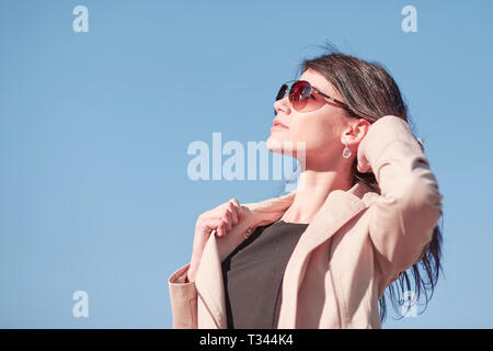 Portrait einer jungen Frau erfolgreich gegen den Himmel Stockfoto