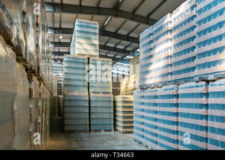 Großes, modernes Lagerhaus mit einigen Waren. Fabrikgebäude oder Lagerhaus mit verpackten Ware versandbereit. Lager mit gepackten Glasflaschen. Stockfoto