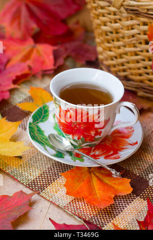 Eine Tasse Tee und Ahornblätter. Herbst Tea Party. Rote Blätter. Geschenke der Natur. Ahornblätter rot Stockfoto