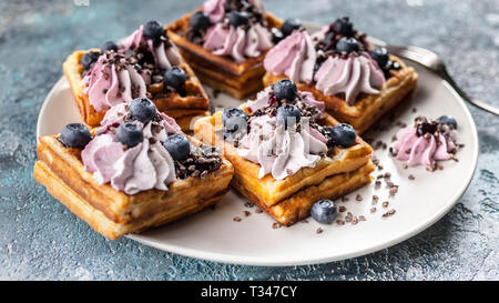 Hausgemachten belgischen Waffeln mit Sahne, Marmelade, Blaubeere und Minzeblättchen. Köstliches Dessert Stockfoto