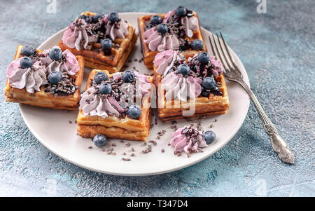 Hausgemachten belgischen Waffeln mit Sahne, Marmelade, Blaubeere und Minzeblättchen. Köstliches Dessert Stockfoto