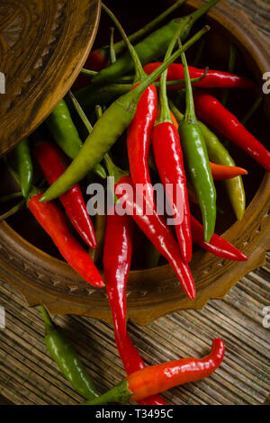 Thai rote und grüne Chilis oder Prik chee fah auch manchmal als Birds Eye Chile Pfeffer feurige Paprika auf 50.000 bis 100.000 Scoville Einheiten bewertet bekannt Stockfoto