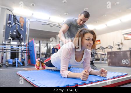 Personal Fitness Trainer arbeiten Übung mit reife Frau in der Turnhalle. Gesundheit Fitness Sport alter Konzept. Stockfoto