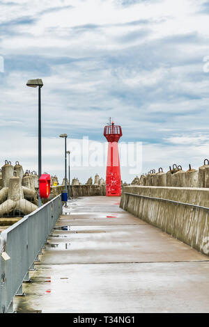 Der rote Leuchtturm ist eine so genannte pier Licht und markiert den Eingang zum Hafen von Kolberg, Westpommern, Polen, Europa Stockfoto