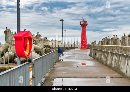 Der rote Leuchtturm ist eine so genannte pier Licht und markiert den Eingang zum Hafen von Kolberg, Westpommern, Polen, Europa Stockfoto