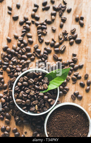 Kaffeesatz und Bohnen auf dem Holztisch mit niemand Stockfoto