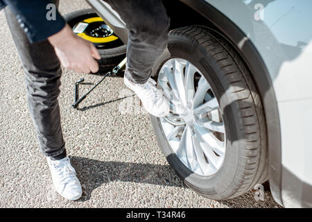 Mann lösen das zerbrochene Rad am Straßenrand, Nahaufnahme Stockfoto