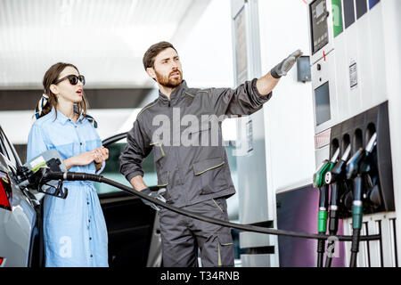 Junge Frau Client mit Tankstelle Arbeiter tanken Auto an der Tankstelle Stockfoto