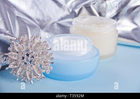 Zwei Gläser der Schönheit Creme mit Silber Schmuck und Silber Tuch auf dem Hintergrund. Stockfoto