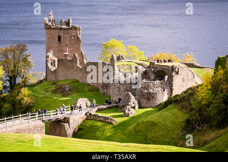 Touristen, die in der Ruine von Urquhart Castle am Ufer des Loch Ness in der Nähe von Inverness in Schottland, Großbritannien. Stockfoto