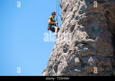 TAURANGA NEUSEELAND - 8. NOVEMBER 2012; junge unternehmungslustige Person rock bis Klettern Schere auf der Seite Mount Maunganui Stockfoto