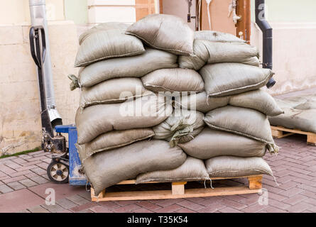 Bau Beutel auf die Holzpaletten mit Lader. Industrie, Gebäude. Stockfoto