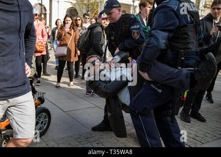 Ein Aktivist, gesehen von der Straße weg von der Polizei mit Gewalt während des Protestes genommen zu werden. "Hochschulen frei von Marxismus" ein Protest gegen die Warschauer Universität ihre Opposition gegen die Aktivität von linksextremisten und andere Fälle von links Express-wing Indoktrination von polnischen Studenten. An der gleichen Stelle, Studenten, Linke und antifaschistische Aktivistinnen versammelten sich unter dem Motto "Hier lernen wir, nicht heil". Beide Gruppen wurden von einem großen Polizei cordon getrennt. Stockfoto