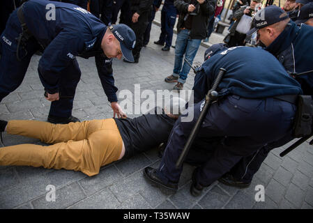 Ein Aktivist, gesehen von der Straße weg von der Polizei mit Gewalt während des Protestes genommen zu werden. "Hochschulen frei von Marxismus" ein Protest gegen die Warschauer Universität ihre Opposition gegen die Aktivität von linksextremisten und andere Fälle von links Express-wing Indoktrination von polnischen Studenten. An der gleichen Stelle, Studenten, Linke und antifaschistische Aktivistinnen versammelten sich unter dem Motto "Hier lernen wir, nicht heil". Beide Gruppen wurden von einem großen Polizei cordon getrennt. Stockfoto