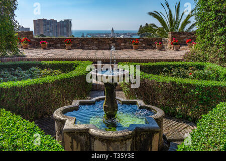 Springbrunnen im Garten und Blick auf die Alcazaba Schloss in Malaga Spanien Stockfoto