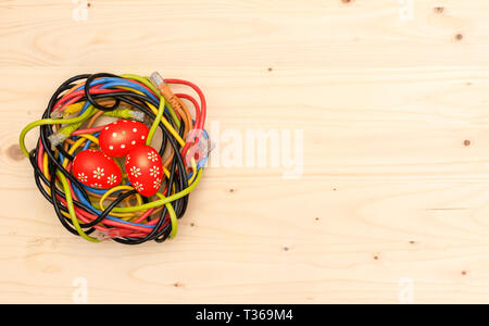 Ostereier und Nest von Internet Kabel auf Holzbrett Stockfoto