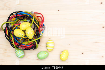 Ostereier und Nest von Internet Kabel auf Holzbrett Stockfoto