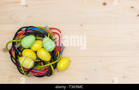 Ostereier und Nest von Internet Kabel auf Holzbrett Stockfoto