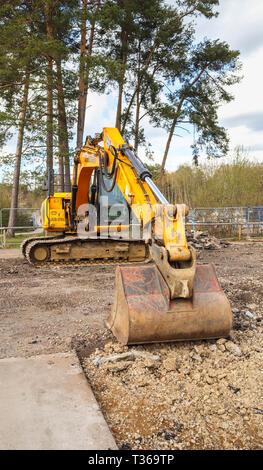 Gelb Caterpillar verfolgt JCB JS 130 LC schwerem Bagger Raupenbagger mit Schaufel Schaufel an der RHS Gärten, Wisley, Surrey, Großbritannien Stockfoto