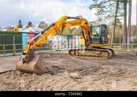 Gelb Caterpillar verfolgt JCB JS 130 LC schwerem Bagger Raupenbagger mit Schaufel Schaufel an der RHS Gärten, Wisley, Surrey, Großbritannien Stockfoto