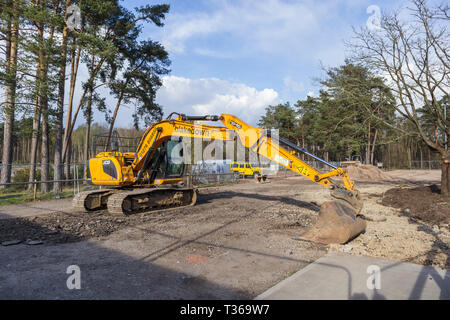 Gelb Caterpillar verfolgt JCB JS 130 LC schwerem Bagger Raupenbagger mit Schaufel Schaufel an der RHS Gärten, Wisley, Surrey, Großbritannien Stockfoto