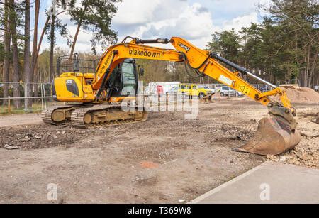 Gelb Caterpillar verfolgt JCB JS 130 LC schwerem Bagger Raupenbagger mit Schaufel Schaufel an der RHS Gärten, Wisley, Surrey, Großbritannien Stockfoto