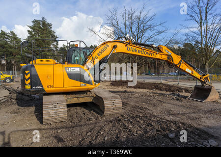 Gelb Caterpillar verfolgt JCB JS 130 LC schwerem Bagger Raupenbagger mit Schaufel Schaufel an der RHS Gärten, Wisley, Surrey, Großbritannien Stockfoto