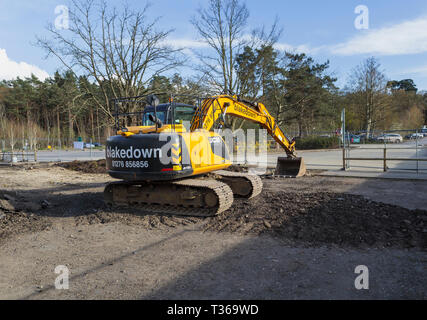 Gelb Caterpillar verfolgt JCB JS 130 LC schwerem Bagger Raupenbagger mit Schaufel Schaufel an der RHS Gärten, Wisley, Surrey, Großbritannien Stockfoto