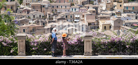 Touristen, die Souvenir Fotos mit traditionellen Kamera in der antiken Stadt Modica Alta berühmt für die barocke Architektur, Sizilien Stockfoto