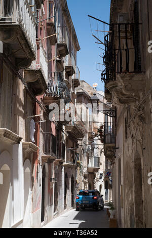 Street Scene kleine Stadt Auto fahren entlang verzierten Gasse über Dione in Ortigia, Syrakus, Sizilien Stockfoto