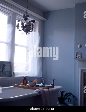 Freistehende Badewanne mit Holz- Rack in Hellblau Badezimmer Stockfoto