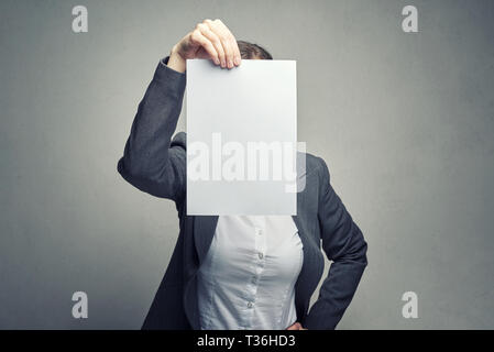 Anonyme business Frau in weißer Bluse und Klage über das Gesicht mit weißem Blatt Papier Stockfoto