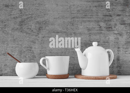 Tasse Tee, Teekanne und Sugar Bowl auf grauem Hintergrund Stockfoto