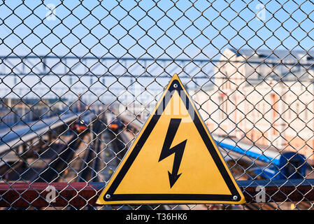 Elektrische Gefährdung unterzeichnen. Blitz auf gelbem Hintergrund. Hohe Spannung Strom am Bahnhof Stockfoto