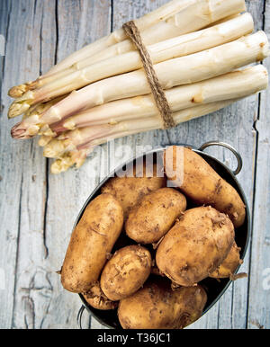 Bündel von frischem ungeschälten weißen Spargel und Kartoffeln Stockfoto