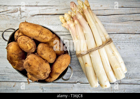 Bündel von frischem ungeschälten weißen Spargel und Kartoffeln Stockfoto