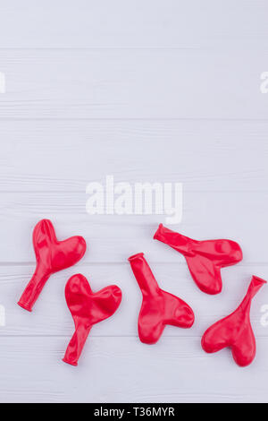 Deflationiert herzförmige Ballons und Kopieren. Valentines urlaub Grußkarte mit fünf rote Luftballons auf Holz- Hintergrund. Stockfoto