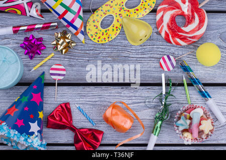 Bunte Urlaub liefert auf grau Holzbretter. Aus bunten Geburtstagsparty Zubehör Rahmen. Konzept der Kindergeburtstag oder Karneval. Stockfoto