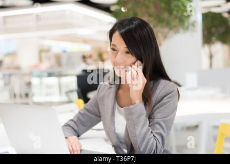 Asiatische junge Business woman Talk auf Handy im Restaurant am Mall Stockfoto