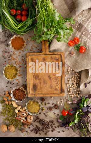 Frischem Gemüse und Tomaten Gewürze Getreide und Nüsse Bio gesunde Snacks auf einer strukturellen Hintergrund. Konzept der gesunden Ernährung. Rahmen unter dem Text. Stockfoto