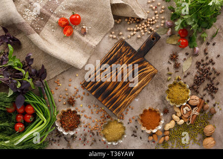 Frischem Gemüse und Tomaten Gewürze Getreide und Nüsse Bio gesunde Snacks auf einer strukturellen Hintergrund. Konzept der gesunden Ernährung. Rahmen unter dem Text. Stockfoto