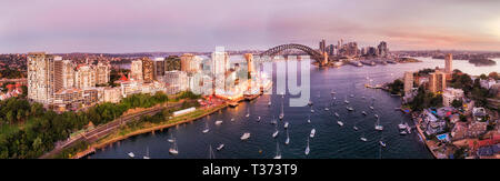 Weiten Panoramablick auf die Skyline von Sydney City CBD Wahrzeichen am Ufer des Hafens von Sydney über Lavender Bay von North Shore bei Sonnenuntergang. Stockfoto