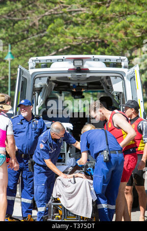 Ein in der Nähe von ertrunken Mann durch Surf rescue Volunteers gespeichert half in einem NSW Rettungswagen auf einer Bahre im Palm Beach, Sydney, Australien Stockfoto