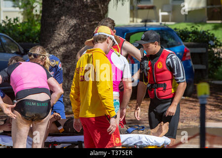 Ein in der Nähe von ertrunken Mann durch Surf rescue Volunteers gespeichert half in einem NSW Rettungswagen auf einer Bahre im Palm Beach, Sydney, Australien Stockfoto