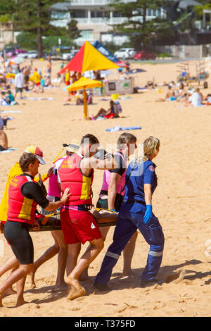 Ein in der Nähe von ertrinken Opfer durchgeführt aus Palm Beach auf einer Bahre durch Surf rescue Volunteers und Rettungsdienst Sanitäter, Sydney, Australien Stockfoto