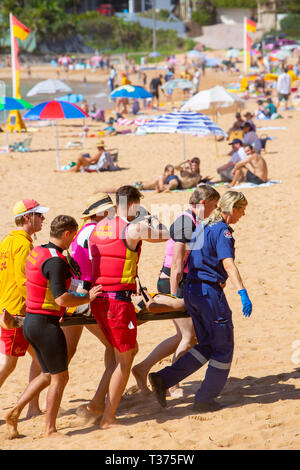 Ein in der Nähe von ertrinken Opfer durchgeführt aus Palm Beach auf einer Bahre durch Surf rescue Volunteers und Rettungsdienst Sanitäter, Sydney, Australien Stockfoto