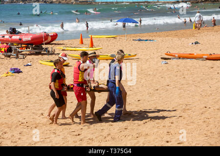 Ein in der Nähe von ertrinken Opfer durchgeführt aus Palm Beach auf einer Bahre durch Surf rescue Volunteers und Rettungsdienst Sanitäter, Sydney, Australien Stockfoto