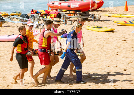 Ein in der Nähe von ertrinken Opfer durchgeführt aus Palm Beach auf einer Bahre durch Surf rescue Volunteers und Rettungsdienst Sanitäter, Sydney, Australien Stockfoto